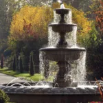 Fontana come caratteristica dell'acqua in un giardino colorato d'autunno