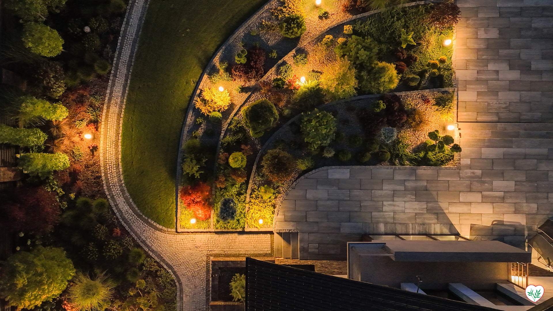 Veduta aerea di un giardino moderno illuminato, con piante sempreverdi per giardini moderni